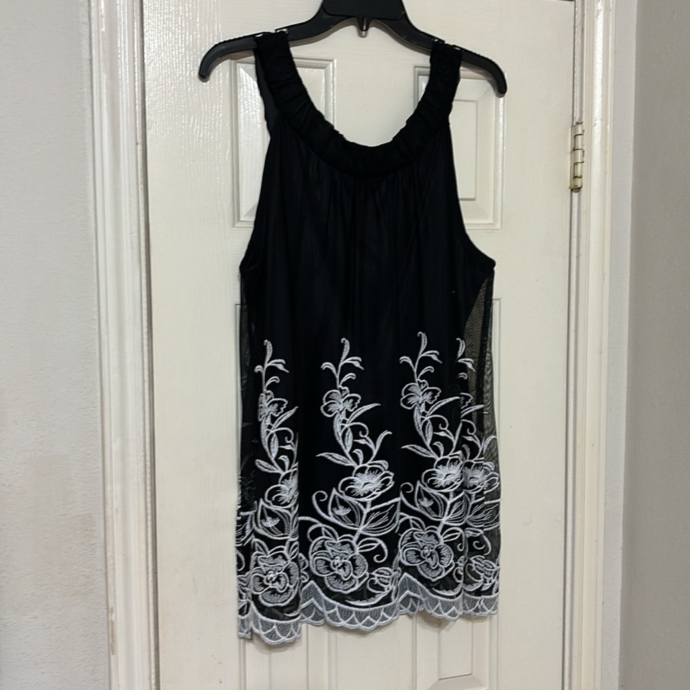 AlFANI sleeveless black blouse with beautiful ornate white designs.